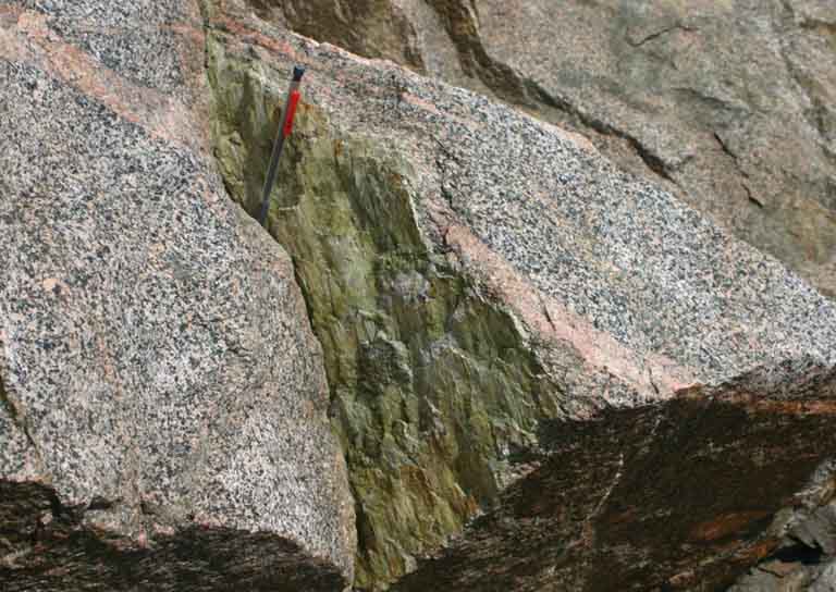 Colour image of gray rock and pencil for scale