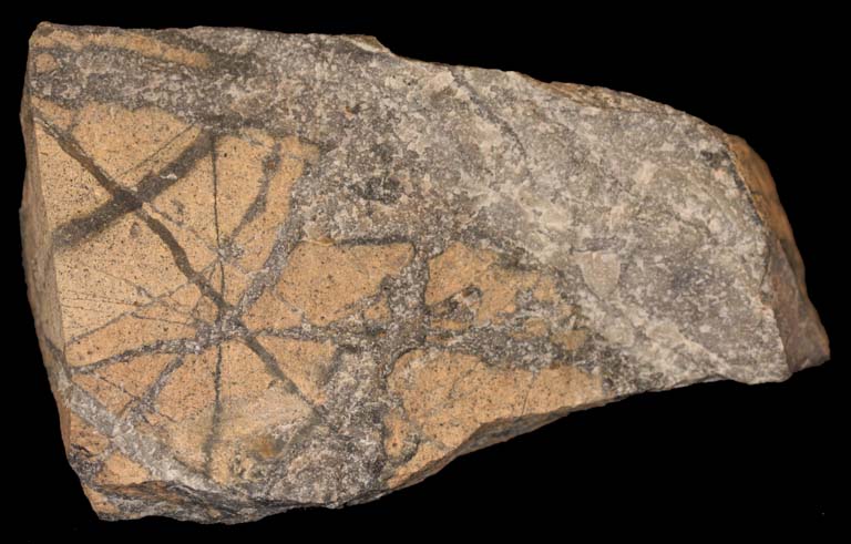 Colour image of brown rocks with light brown facing crossed with brown stripes