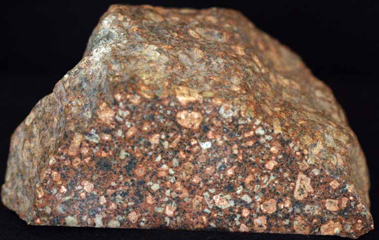 Colour image of brown rock mottled with black and yellow spots