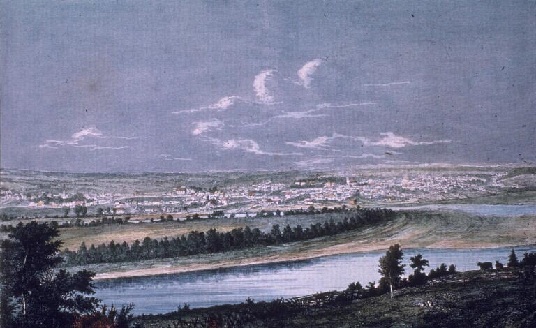 Colour print of deep blue sky, river and town in the distance